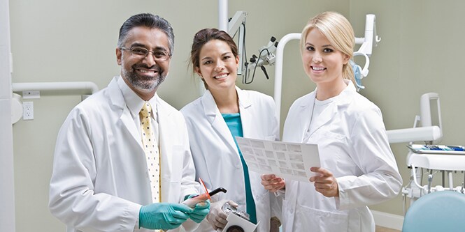 Three doctors in dentist office together
